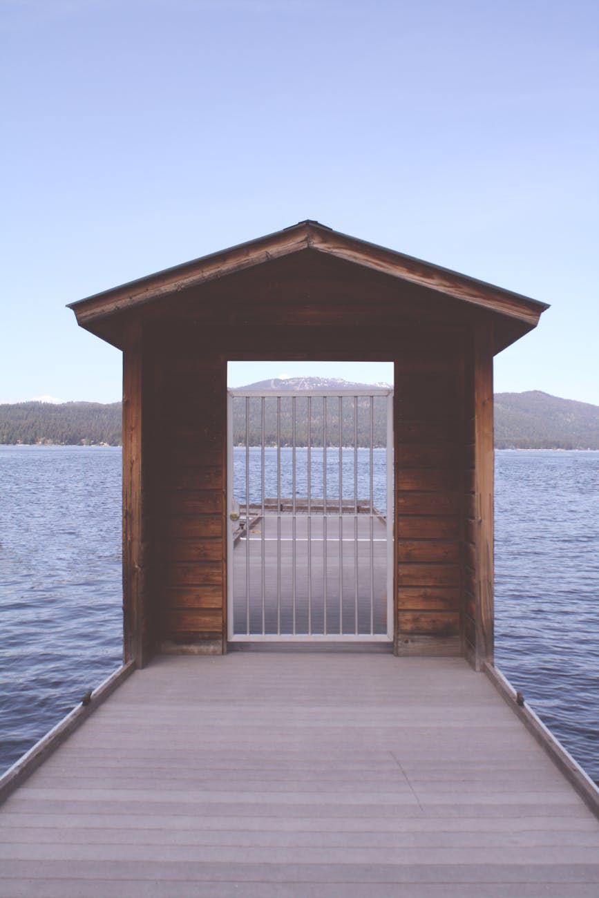 brown wooden dock with white metal fence